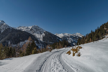 Fototapeta na wymiar Snowy path near Riesachsee in cold sunny fresh beautiful day in Austria