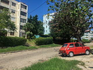 Street on the outskirts of the city of Havana, Cuba. Sunny day, green grass, asphalt and trees.