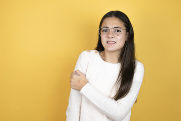 Fototapeta premium Beautiful child girl wearing casual clothes with pain on her shoulder and a painful expression