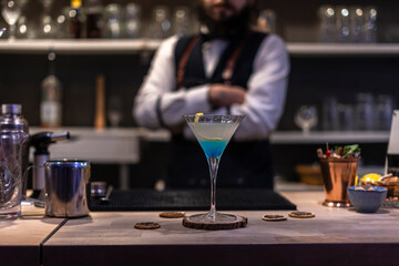 Expert barman is making cocktail at night club.