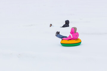 Fototapeta na wymiar people riding snow tubing at winter park