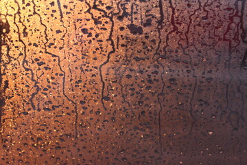 Natural background of condensation of water on a window glass with high air humidity, large drops dripping. Natural sunlight through glass. High humidity