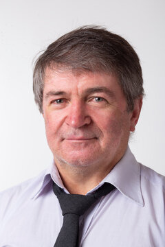 Portrait Of Caucasian Adult Man With Green Eyes And Rosacea, Brown Hair And Gray Hair. He Wears A White Shirt And A Black Tie. Isolated On White Background. Cut Out.