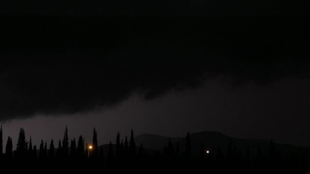 Thunderstorm at summer night. Lightning flashes over the park on summer rainy night