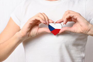 Love Czech Republic. The girl holds a heart in the form of the flag of Czech Republic on her chest....