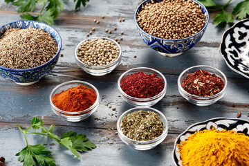 Various spices in bowls on grey table. Paprika, turmeric, red pepper, cumin, coriander. Powdered spices - obrazy, fototapety, plakaty