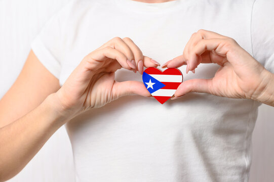 Love Puerto Rico. The girl holds a heart in the form of the flag of Puerto Rico on her chest. Puerto Rican patriotism concept