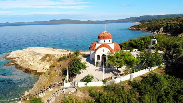 Aerial drone view of the Nea Roda church situated on the Aegean sea coast, Greece. Land on the background