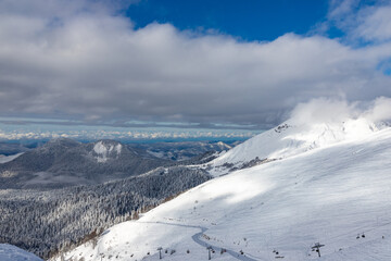 Snow-covered mountains and ski slopes with clouds on background. Ski resort Roza Khutor. Sochi. Russia. © umike_foto