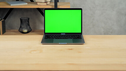 Modern laptop computer display with mock up chroma key green screen standing on table working...