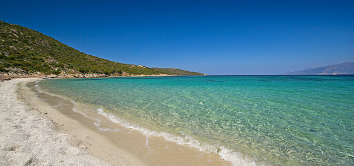 Deserted beach with turquoise and transparent sea between the 