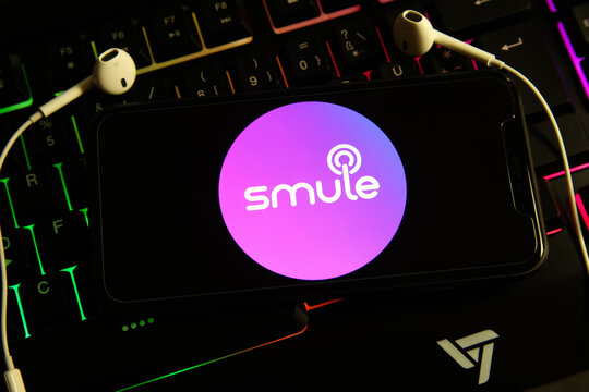 Viersen, Germany - February 9. 2021: Closeup of isolated smartphone screen with logo lettering of smule music app on illuminated computer keyboard
