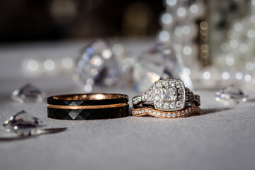 Black and silver wedding rings in a bed of pearls