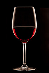 Glass of red wine on black background.