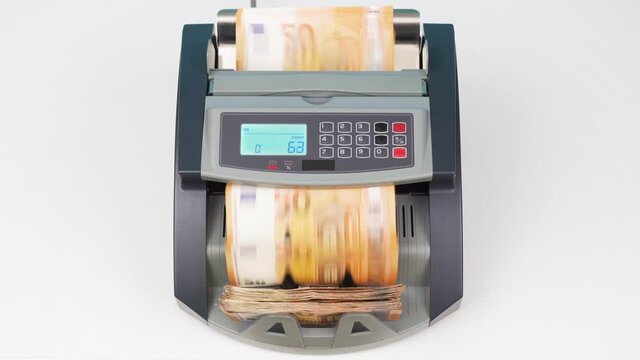 Currency counting money machine counts 50 euro bills or euros banknotes. Finance concept. Counter machine stands on white table in office or branch. Mechanism for bank financial operations