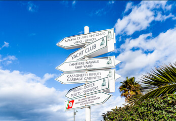 Direction signs pointing harbor, yacht club, toilets and garbage dumpster in the marina of San Vincenzo, province of Livorno, Tuscany, central Italy