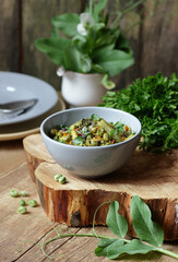 Vegan protein meal, dish of assorted stewed green legume vegetables: peas, green bean, broccoli garnished with parsley and flower petals, closep, vertical, vegan food concept