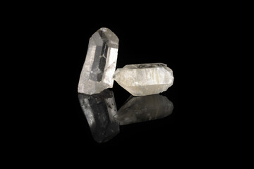 Natural mineral rock specimen - rock crystal of quartz gemstone from Subpolar Ural on black glass background.