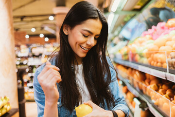 Portrait happy young beautiful woman shopper standing in supermarket