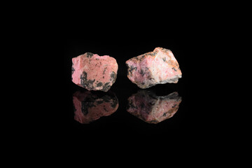 Natural mineral rock specimen - rough rhodonite stone from M. Sidelnikovo, Ural, Russia on black...