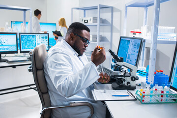 Professional African-American scientist is working on a vaccine in a modern scientific research laboratory. Genetic engineer workplace. Future technology and science.