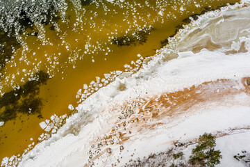 Ice blocks drifting around in a calm sea water creating interesting aerial patterns. Shot from drone