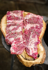 Raw hanging tender or onglet steak of beef on wooden Board. Preparing meat for barbecue grilling. BBQ.