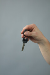 Hand with key in front of wall