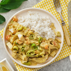 Fish in sauce with vegetables and rice.