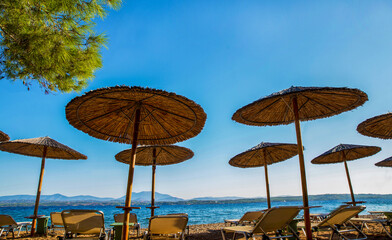 sunshade awnings  and beach loungers on the amazing  beach  on idyllic greek island Spetses