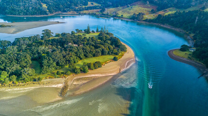 Aerial view of a beautiful river running through a green hillside to the Tasman sea. Auckland New Zealand.