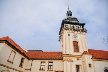 Church of the Nativity of the Virgin Mary near renaissance castle, chateau with park, footpath in garden on sunny winter day, Benatky nad Jizerou, Central Bohemian, Czech Republic