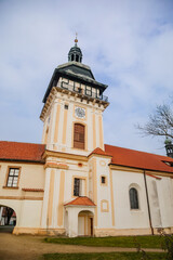 Church of the Nativity of the Virgin Mary near renaissance castle, chateau with park, footpath in garden on sunny winter day, Benatky nad Jizerou, Central Bohemian, Czech Republic