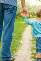 the parent holding the child's hand with a happy background