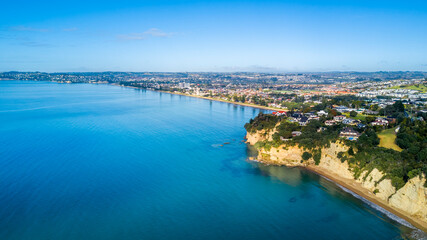 Aerial view of a beautiful suburb on the shore of a quiet harbour on a sunny morning. Auckland, New...