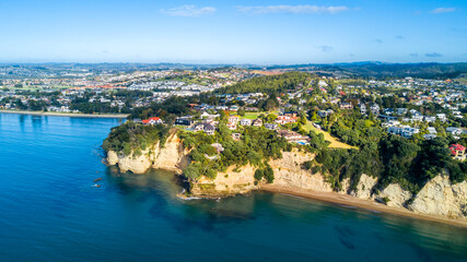 Fototapeta na wymiar Aerial view of a beautiful suburb on the shore of a quiet harbour on a sunny morning. Auckland, New Zealand