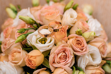 Bridal bouquet with orange roses. Gold wedding rings