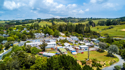 Obraz premium Aerial view of a little village in the middle of the countryside spotted with farms and forest. Auckland, New Zealand.