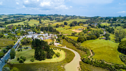 Aerial view of a little village in the middle of the countryside spotted with farms and forest....