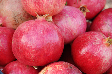 Ripe pomegranate fruits background. Fresh red pomegranates at grocery store. Organic food concept.