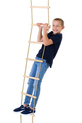 Teenage boy climbiing on rope ladder © lotosfoto