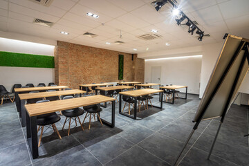  Interior of an empty classroom conference hall with black chairs,  flipcharts and white screen.