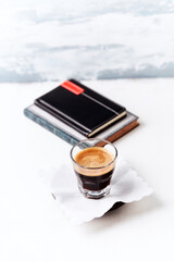 Coffee in glass cup on bright wooden background. Copy space.