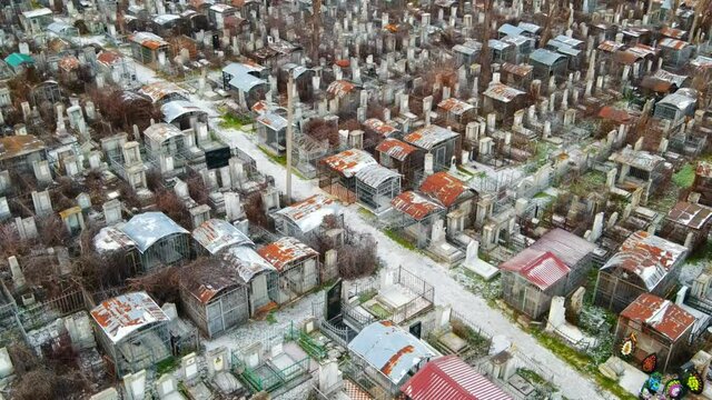 Aerial drone view of a cemetery in Chisinau, Moldova. Multiple graves, crypts, walkway, Cloudy weather, bare trees, winter
