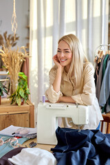 tailor making a garment in her workplace, stand in contemplation looking at side, have rest. hobby sewing as a small business concept. in bright modern room. fashion, style concept