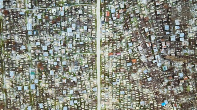 Aerial drone view of a cemetery in Chisinau, Moldova. Multiple graves, crypts, walkway, Cloudy weather, bare trees, winter