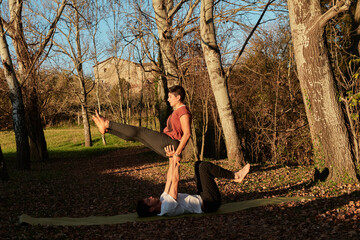 couple practicing acroyoga outdoors, balance