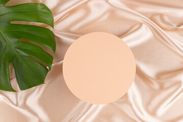 Geometric platform podium and monstera leaf on pastel silk satin background. Blank minimal round...