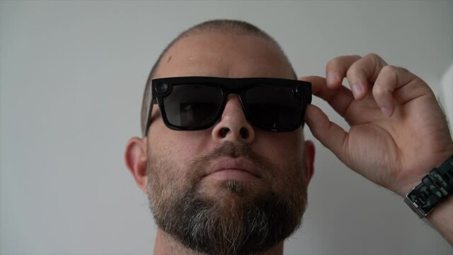 Bearded man wearing futuristic video recording sunglasses