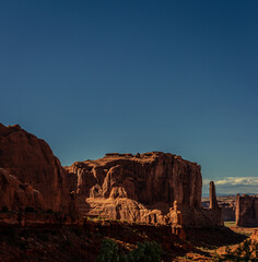 Large red sandstone monolit with sandstone tower and pipes in Arches national park in Utah, america